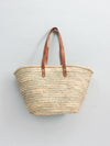 Basket bag with long tan leather straps.