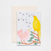 Greetings card depicting a pink bird and a yellow bird perched on a branch. Text reads happy birthday, the letters are jumbled so it looks like the birds are singing.