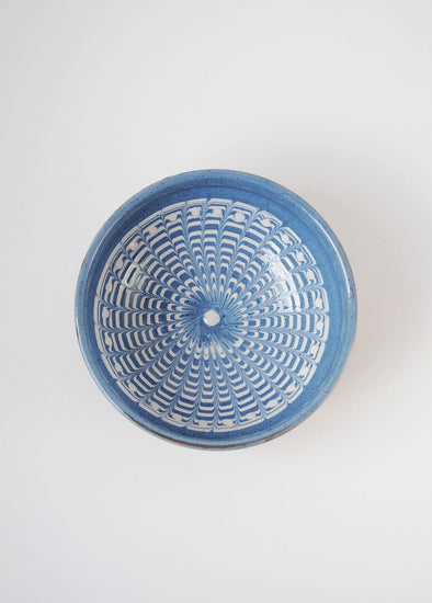 Ceramic bowl decorated in traditional Romanian pattern. Blue base with swirls of white.