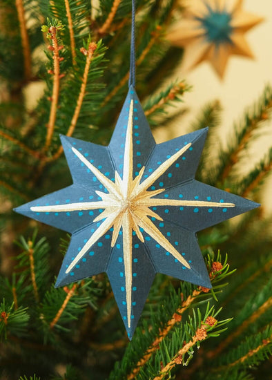 Blue star-shaped ornament on a Christmas tree