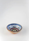 Ceramic bowl decorated in traditional Romanian pattern. Blue base with swirls of black, blue, green, white, red, brown and yellow.