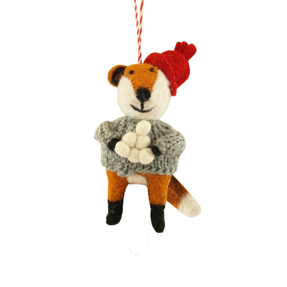 Felt fox ornament wearing a red hat and gray sweater on a white background