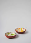 Two ceramic small bowls. One has a white glaze with orange and yellow splatter pattern on interior and the other has a white glaze with green splatter pattern on interior. Both have a terracotta glaze on exterior.