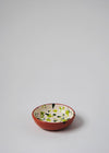 Ceramic small bowl. White glaze with green splatter pattern on interior and terracotta glaze on exterior.