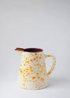 Ceramic large jug. White glaze with orange and yellow splatter pattern on exterior, terracotta glaze on interior.