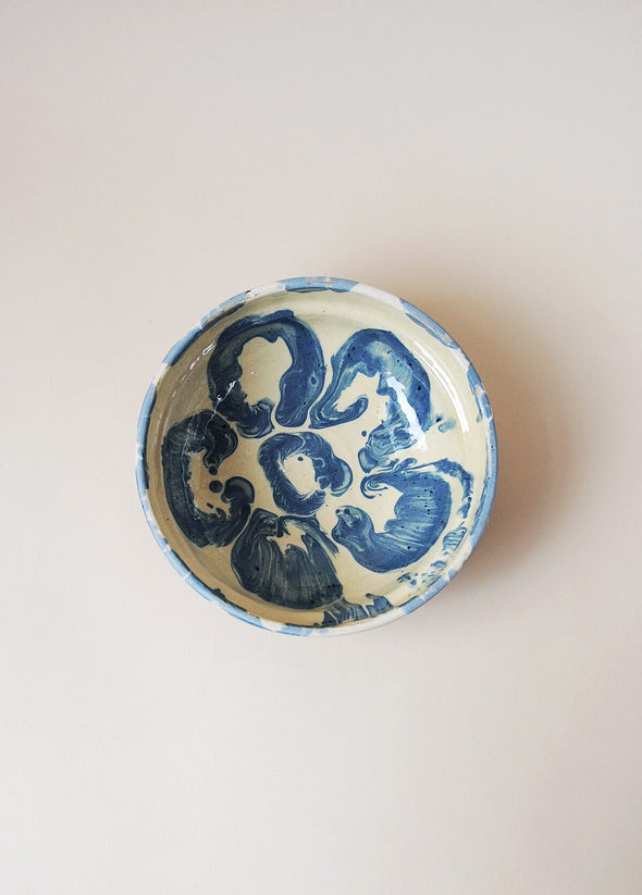 Ceramic bowl decorated in traditional Romanian pattern. Cream base with a blue glaze pattern.