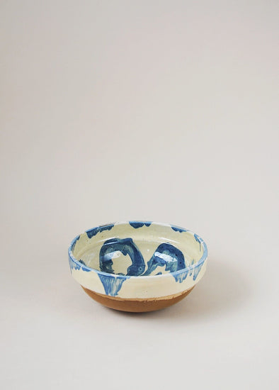 Ceramic bowl decorated in traditional Romanian pattern. Cream base with a blue glaze pattern.