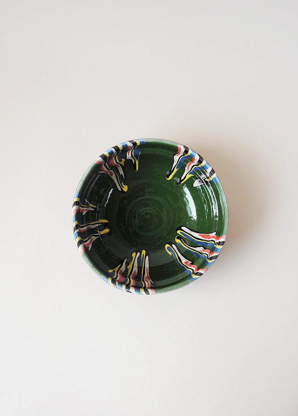 Ceramic bowl decorated in traditional Romanian pattern. Green base with patterned glaze in red, blue, yellow, cream and black.