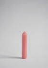 A short dusky pink dinner candle.