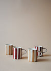 Four espresso cups. Two are white with light brown stripes, and two are white with burgundy stripes.