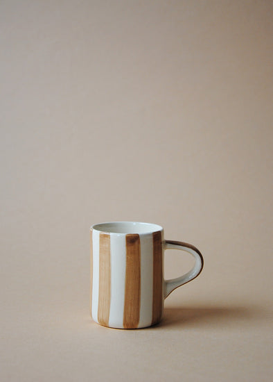 Light brown and white striped ceramic espresso cup.