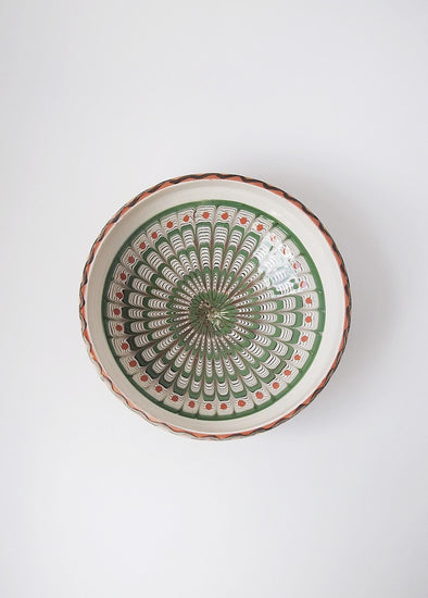 Ceramic bowl decorated in traditional Romanian pattern. Cream base with swirls of green, black and terracotta.