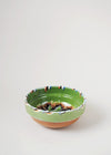 Ceramic bowl decorated in traditional Romanian pattern. Green base with patterned glaze in orange, blue, yellow, cream and black.