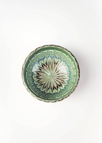 Ceramic bowl decorated in traditional Romanian pattern. Green base with swirls of black, blue, white, red and yellow.