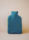 Knitted hot water bottle cover in blue and green stripes.