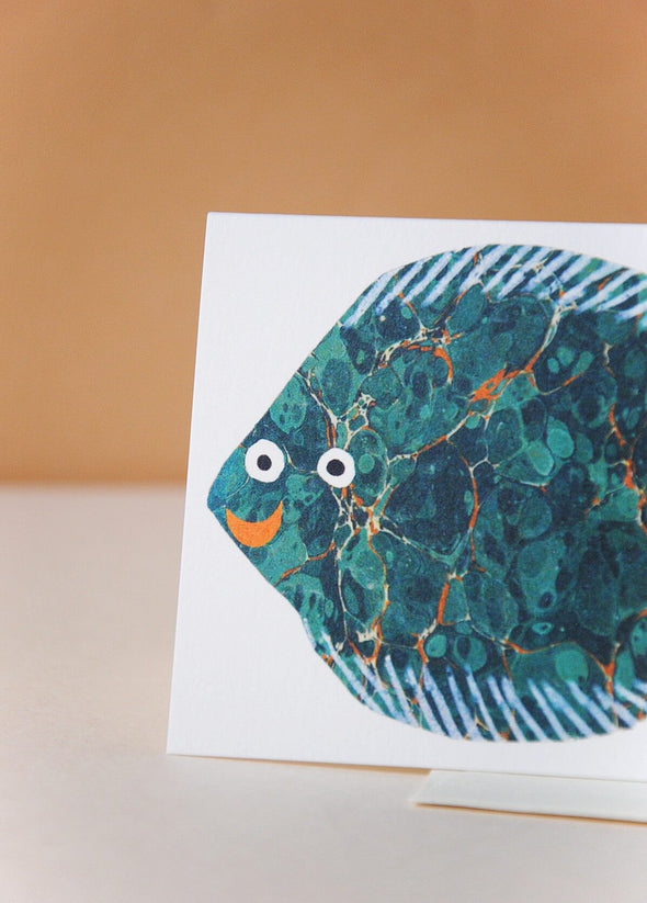 Greetings card with a fish design. The fish is blue and turquoise with a red smiling mouth.