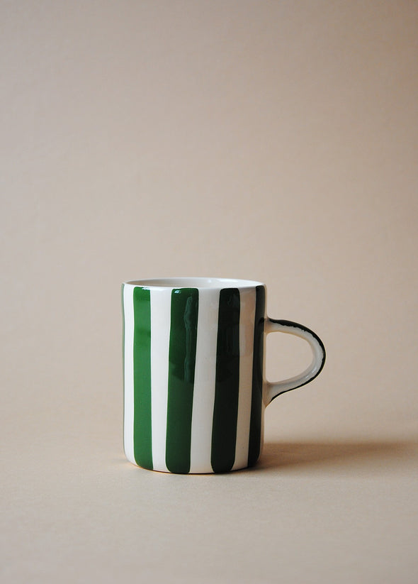 White ceramic mug with dark green painted stripes.