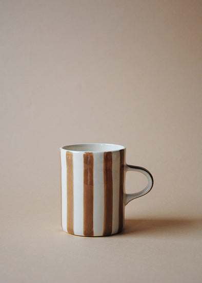 White ceramic mug with painted light brown stripes.