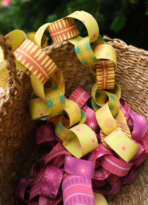 A basket filled with red & pink and yellow & green paper chains. 