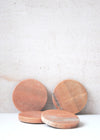 Four rose coloured marble coasters, with an individual diameter of ten centimetres each.