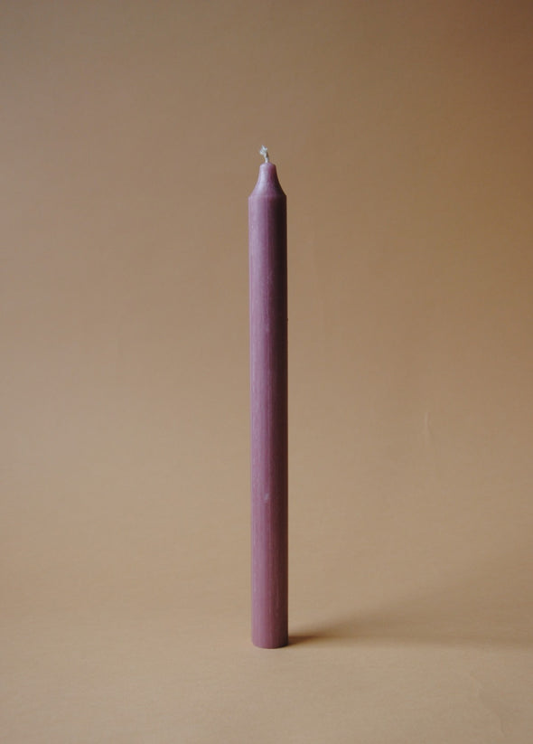 A tall dusky pink dinner candle.