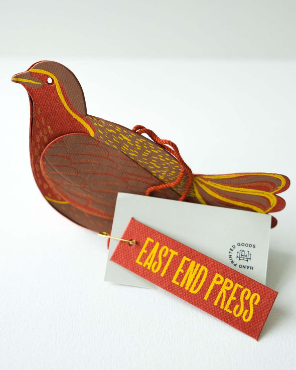 A red robin hanging decoration made from paper board.