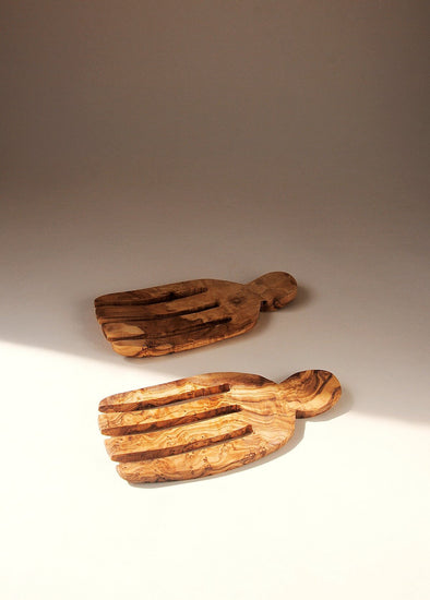 Pair of wooden salad hands half in shadow.