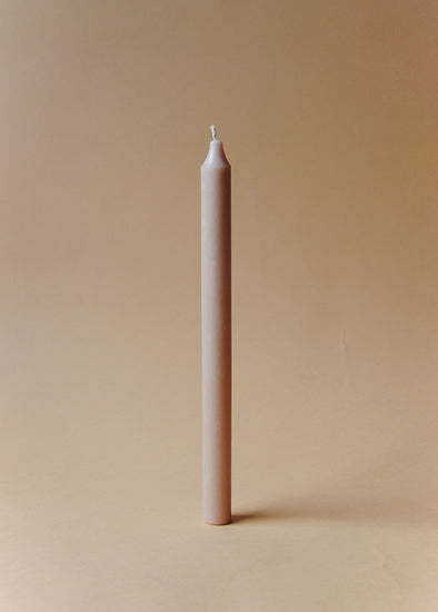 A tall beige dinner candle.