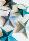 Decorative star ornaments in different shades of blue, on a light background