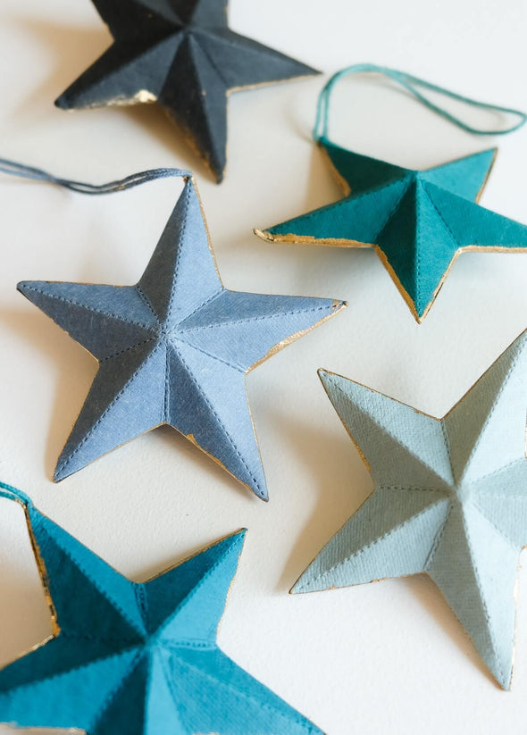 Decorative star ornaments in different shades of blue, on a light background