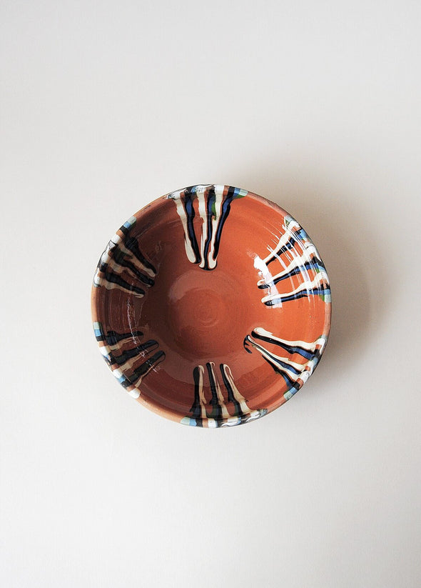 Ceramic bowl decorated in traditional Romanian pattern. Terracotta base with a striped design in cream, green and blue.