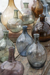 A collection of glass vases in green, blue, purple and brown glass.