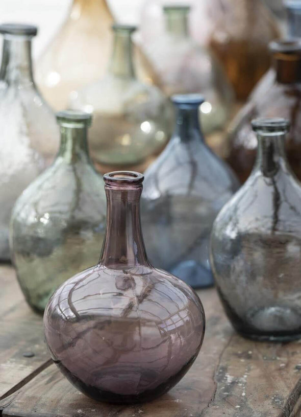 A collection of glass vases in purple, green, blue and brown glass.