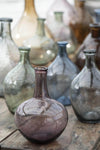 A collection of glass vases in purple, green, blue and brown glass.
