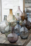 Collection of glass vases in purple, blue, green, brown and grey glass.
