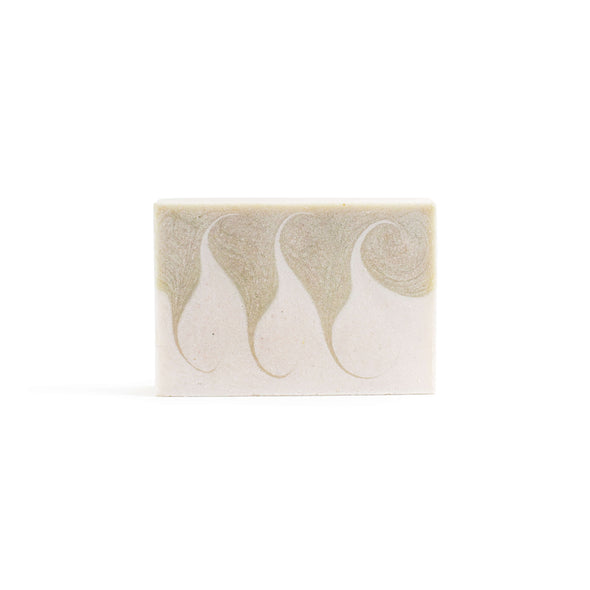 A rectangular soap with a white and pale green wave pattern.