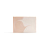 A rectangular soap with a white and pinky orange wave pattern.