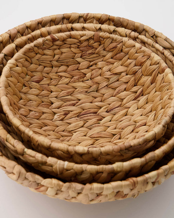 Three bowl shaped baskets in a small, medium and large size sitting inside each other. Made from water hyacinth.