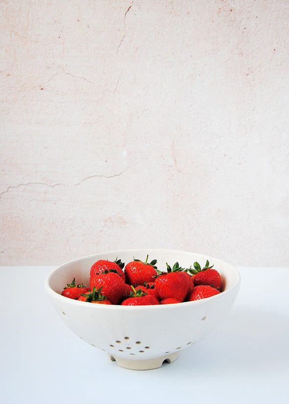 Ceramic berry bowl in a white glaze. The bowl is full of red strawberries. The bowl is 9.5cm high and 21.3cm wide at the top.