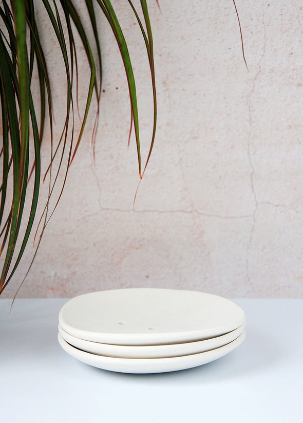 Three white porcelain circular soap dishes stacked on top of each other. Each dish measures approximately 14cm across.