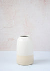 Freckled ceramic bottle vase. The top two thirds are covered in a white glaze while the bottom is left raw. The vase is 13cm high and 8cm wide (at base).