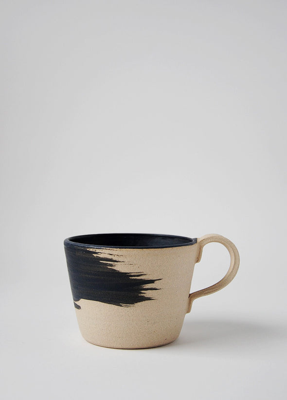 Stoneware mug with a raw finish and a matt black brush stroke design on the exterior. The interior of the mug is painted in a matt black glaze.