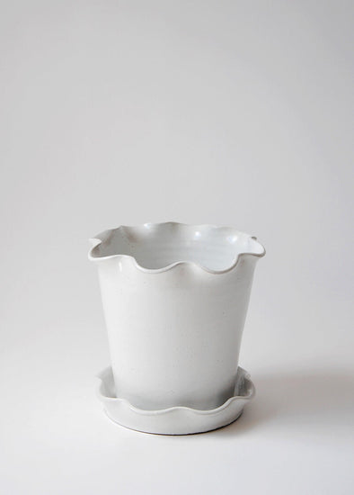 Stoneware planter and saucer with a white glaze. Both planter and saucer have a frilly edge.