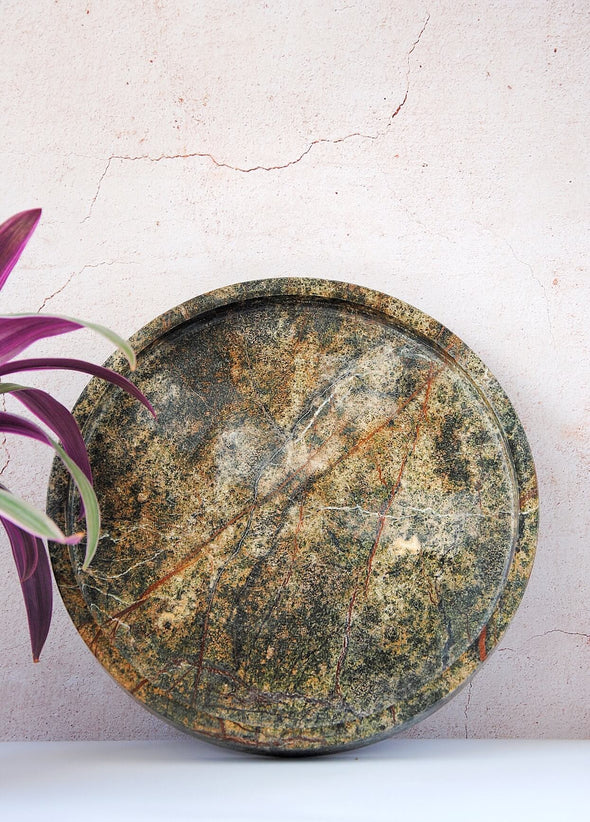 Round tray made from one hundred percent green marble. Thirty centimetres wide and the edges are four centimetres high.