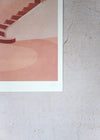 Close up of a corner of a print by Charlotte Taylor. Depicting a staircase and the surrounding walls in varying tones of pink. The print has a white border and is hand signed by the artist in the corner.