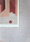 Close up of a corner of a print by Charlotte Taylor. Depicting an architectural image featuring stairs, arches, walls and spherical balls in pinks, reds and cream. The print has a white border and is hand signed by the artist.