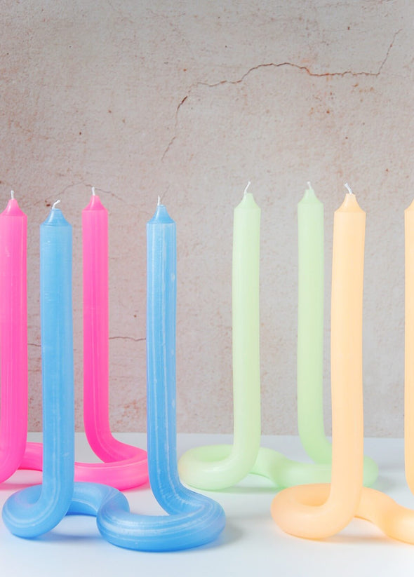 Four twist candles handmade by Dutch designer Lex Pott. One is blue, one peach, one pink and one mint green. Each candle is double ended, made entirely out of wax and formed in such a way it stands alone on a twisted s shape base.